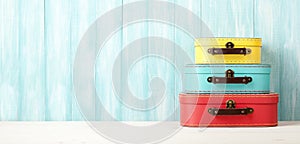 Travel concept with retro style suitcases on blue wooden background