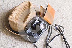 Travel concept, straw hat/boater with black vintage camera and brown wallet