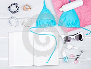summer women& x27;s fashion with blue swimsuit, book, pink towel, cos