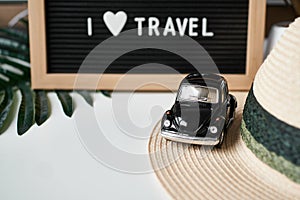 Travel concept. toy car,hat,letter board with inscription I love Travel on the background