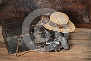 Travel concept with Vintage suitcase old camera on wooden floor.