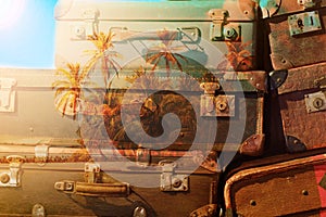 Travel concept -vintage suitcase and palm tree island double exposure