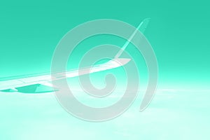 Travel concept. Wing of airplane flying above the clouds in trendy color sky. Mint green and turquoise color. Copy space