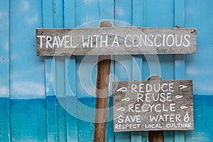 Travel with a conscious wooden sign on blue wooden background