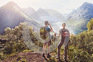 Travel, couple of hikers with backpacks relaxing and taking photos during trek