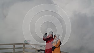 Travel couple take selfie on the geyser`s cloud background