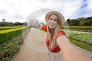 Travel in Curitiba, Brazil. Beautiful smiling girl takes self portrait in the Botanical Garden of Curitiba, Parana, Brazil