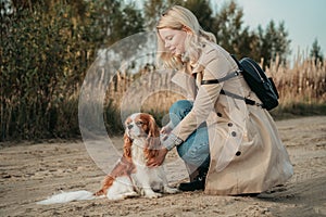 Travel with dog. Young woman walk with her cocker spaniel, backpack on her shoulder