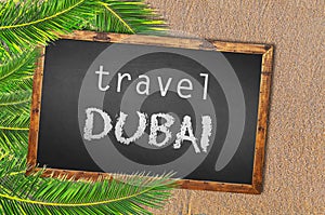 Travel Dubai palm trees and blackboard on sandy beach