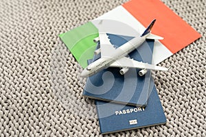 Travel flight to Italy concept. Toy airplane model with passport and Italy flag