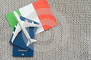 Travel flight to Italy concept. Toy airplane model with passport and Italy flag