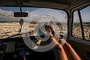 Travel and freedom concept people with close up of woman legs enjoy the road trip inside an old vintage van - vanlife lifestyle