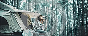 Travel and freedom lifestyle people concept. Happy woman sit and enjoy relax on the roof tent car. Adventure and alternative road