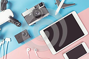 Travel gadgets on blue and pink background for travel concept