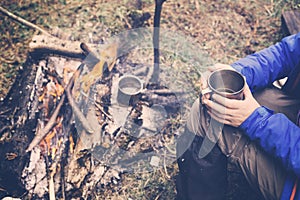 Travel girl drinking from a mug. Camping hiking lifestyle.