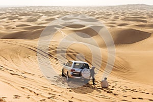 Travel guide men with four wheel drive car on the great desert at Dubai