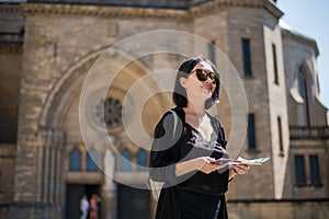 Travel guide, tourism in Europe, woman tourist with map on the street.