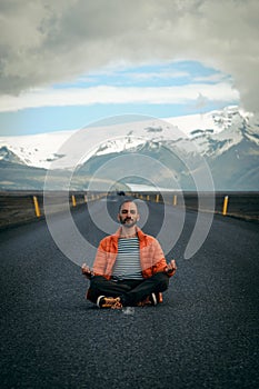 Travel hitchhiker man meditating on a road