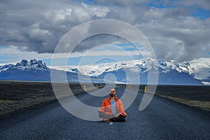 Travel hitchhiker man meditating on a road