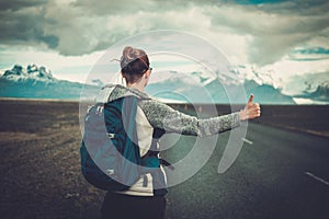 Travel hitchhiker woman walking on a road