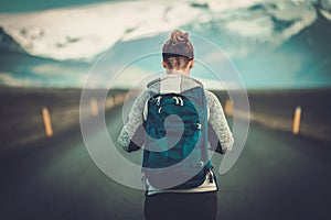 Travel hitchhiker woman walking on a road