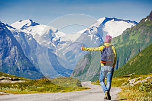 Travel hitchhiker woman walking on road during holiday travel photo