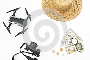Travel holiday concept with copy space. Drone, straw hat, camera, vintage compass and USA banknotes with coins on white background
