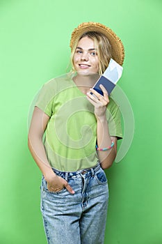 Travel Ideas. Dreaming Winsome Llovely Smiling Young Girl in Straw Hat Holding Passport with Tickets isolated Over Trendy Green
