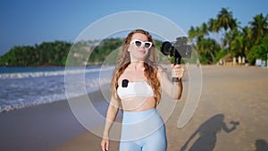 Travel influencer films beach vlog using pro camera, lav mic, sharing tips, capturing scenic landscape, engaging viewers