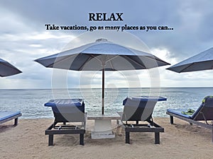 Travel inspirational quote - Relax. Take vacations, as many as you can. On background of beach umbrella and wooden deckchair in