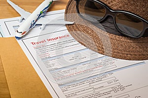 Travel Insurance Claim application form and hat with eyeglass on