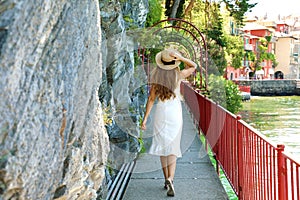 Travel in Italy. Back view of tourist girl runs the Walk of Lovers in Varenna on Lake Como, Italy photo
