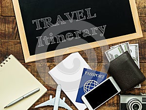 Travel itinerary handwritten with white chalk on a blackboard decorate with plane model, passport, money wallet , notebook