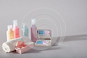 Travel kit. Set of four small plastic bottles for cosmetic products, kit for contact lenses, pill organizer, towel.
