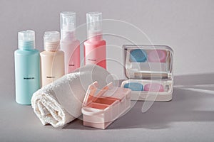 Travel kit. Set of four small plastic bottles for cosmetic products, kit for contact lenses, pill organizer, towel.