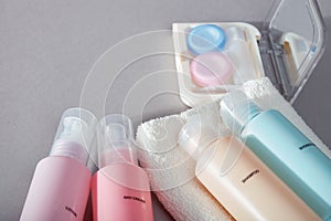 Travel kit. Set of four small plastic bottles for cosmetic products, kit for contact lenses, towel.