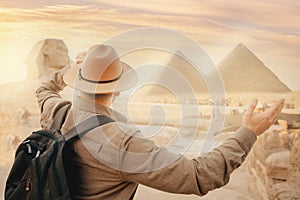 Travel man in hat background pyramid of Egyptian Giza and Sphinx, sunset Cairo, Egypt