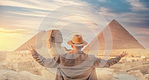 Travel man in hat background pyramid of Egyptian Giza and Sphinx, sunset Cairo, Egypt