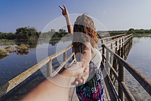 Travel nature follow me woman in a natural park holding hand of boyfriend following leading girlfriend walking. Tourism, love and