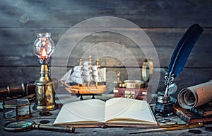 Travel and nautical theme grunge background. Old book, compass, telescope, divider, coins, shell, map, hourglass, quill pen on