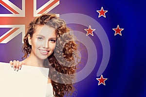 Travel in New Zealand. Happy girl student with white banner and New Zealand flag