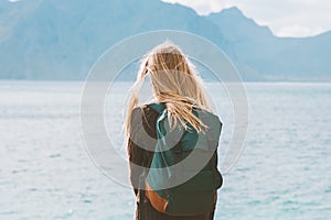 Travel in Norway globetrotter woman with backpack looking at mountains view alone outdoor