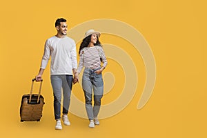 Travel Offer. Smiling Arab Couple Walking With Suitcase And Looking Aside