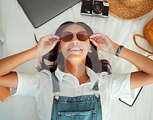 Travel packing, woman and happiness of a person with sunglasses on a hotel bed ready for adventure. Clothing, technology