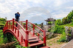 Travel photographer man with professional camera taking photos of Japanese garden