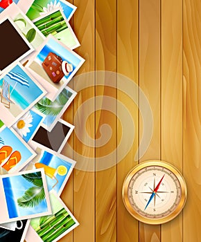 Travel photos and compass on wood background.