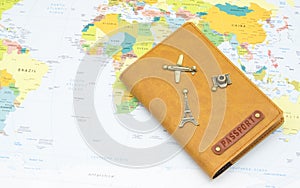 Travel Plan concept. Passport in cover with travel items decoration on world map background. (Focus Stacking image