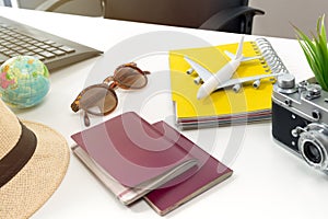 Travel planning concept at office with passports sunglases and computer photo