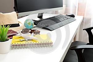 Travel planning concept at office with passports sunglases and computer photo