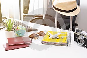 Travel planning concept at office with passports sunglases and computer photo